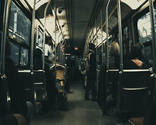 Commuter looking out the window on a city bus during evening traffic